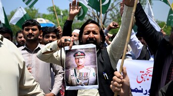 A man carries a portrait of Pakistani Army Chief General Syed Asim Munir, during a rally to express solidarity with Pakistan's armed forces, in Islamabad on May 14, 2025.
