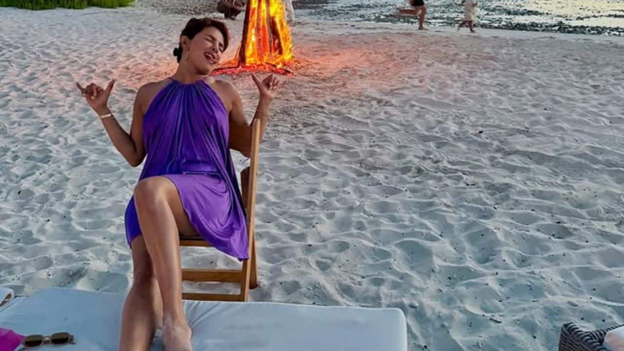 Priyanka Chopra Priyanka recently celebrated her birthday with a beach vacation along with Nick Jonas and daughter Malti at a dusky evening with a bonfire in the background. She is seated on a lounge chair and is wearing a vibrant purple halter-neck dress or top. Priyanka Chopra Priyanka recently celebrated her birthday with a beach vacation along with Nick Jonas and daughter Malti at a dusky evening with a bonfire in the background. She is seated on a lounge chair and is wearing a vibrant purple halter-neck dress or top.