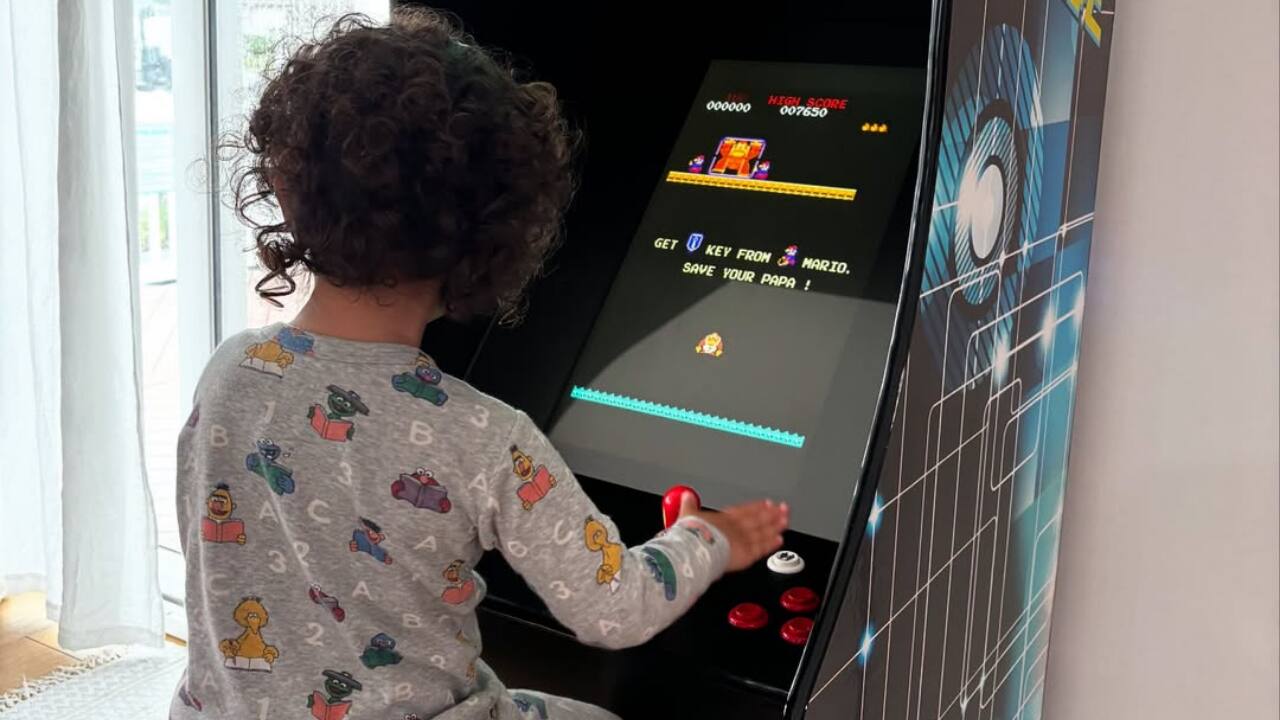 Another photo shows Malti immersed in a video game on a classic arcade machine, showcasing her playful side.