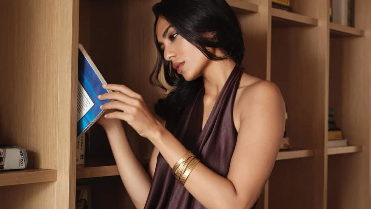 Literary leanings   Surrounded by art and books, Sobhita reaches for a title with purpose. This candid moment reveals her intellectual side, while her outfit conveys contemporary festive elegance. 