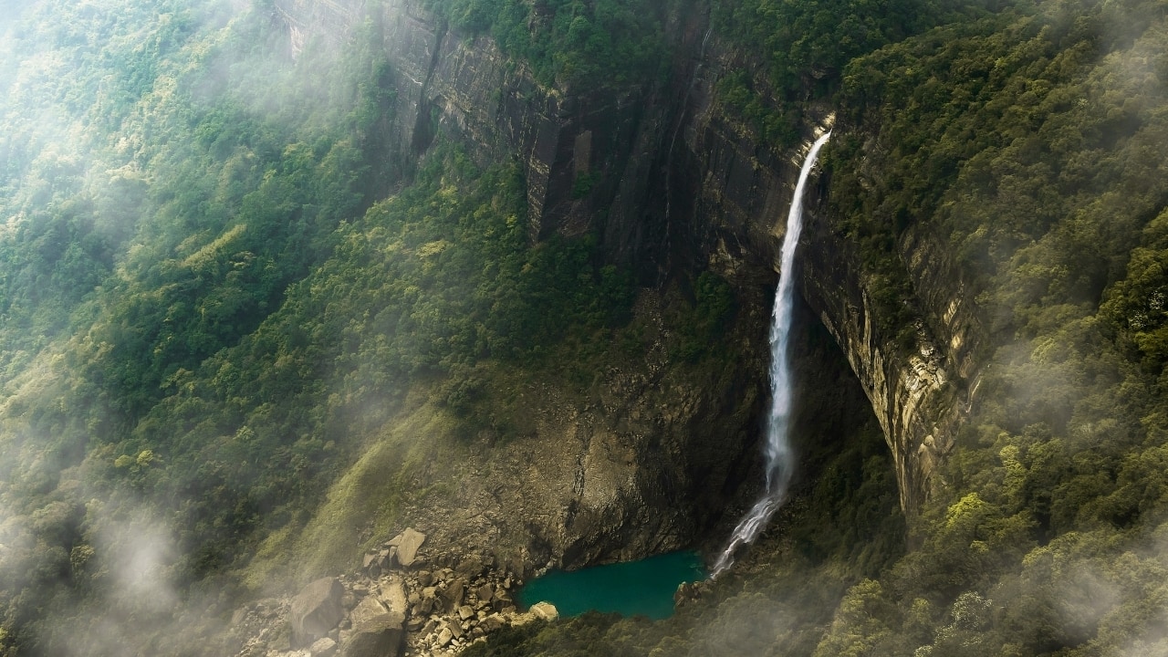 7. Nohkalikai Falls, Meghalaya – A Plunge into Legend India’s tallest plunge waterfall at 340 metres, Nohkalikai near Cherrapunji is best viewed when the monsoon is in full flow. Shrouded in Khasi folklore and perpetual mist, it invites contemplation and quiet awe. The nearby root bridges and caves only deepen the region’s enigmatic appeal. (Image: Canva)