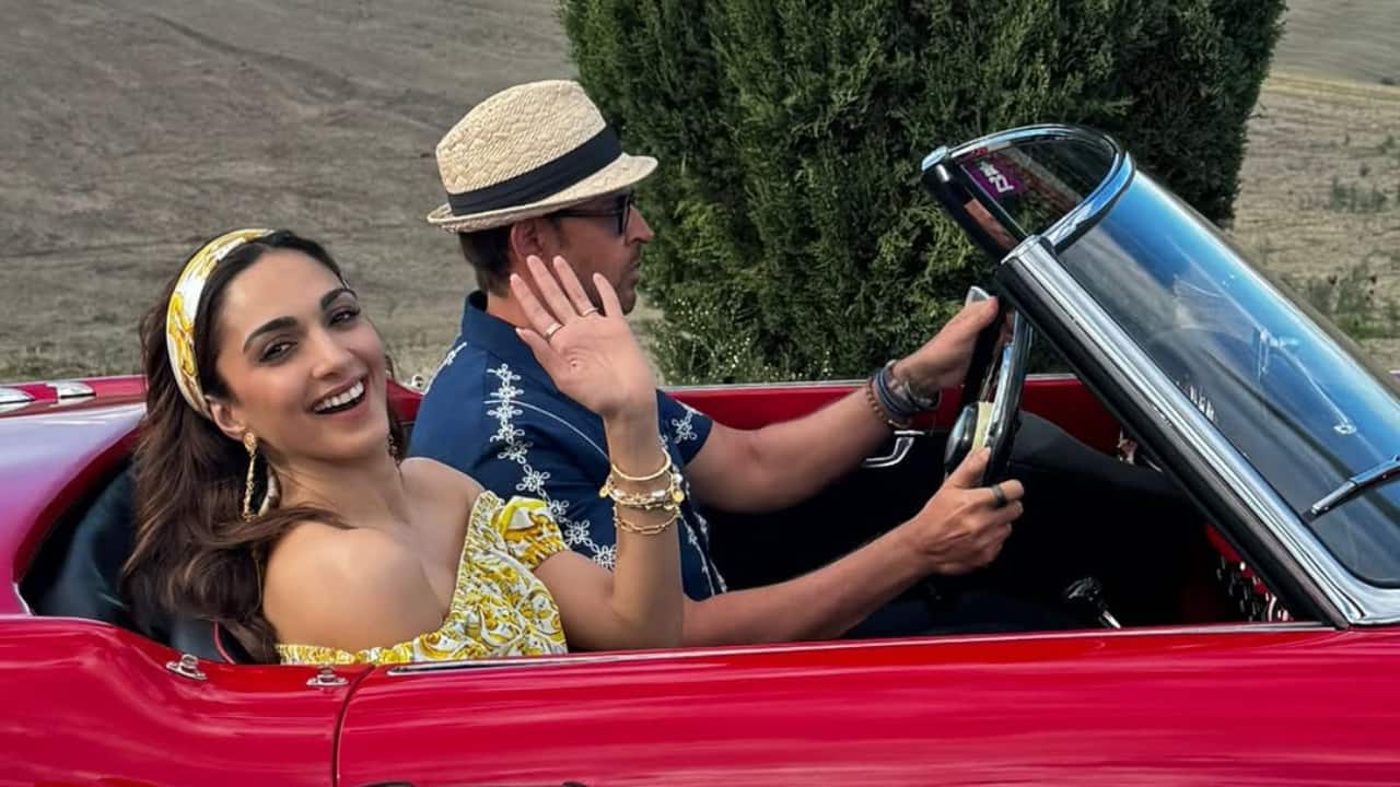 Cruising through scenic roads in a red vintage convertible. Kiara’s smile says it all—filming with joy and style for War 2.