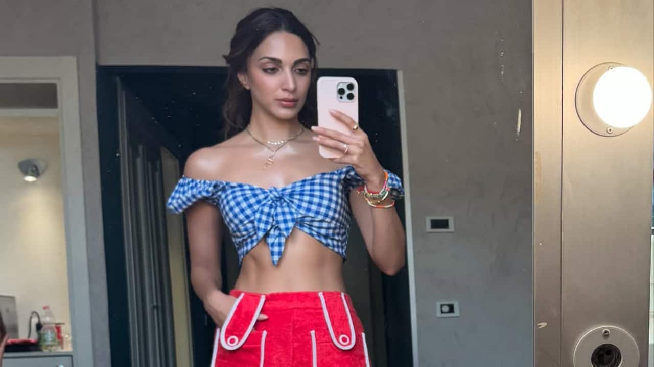 Serving retro-chic in a blue checkered top and bold red shorts. Kiara’s BTS look screams playful yet effortlessly stylish.