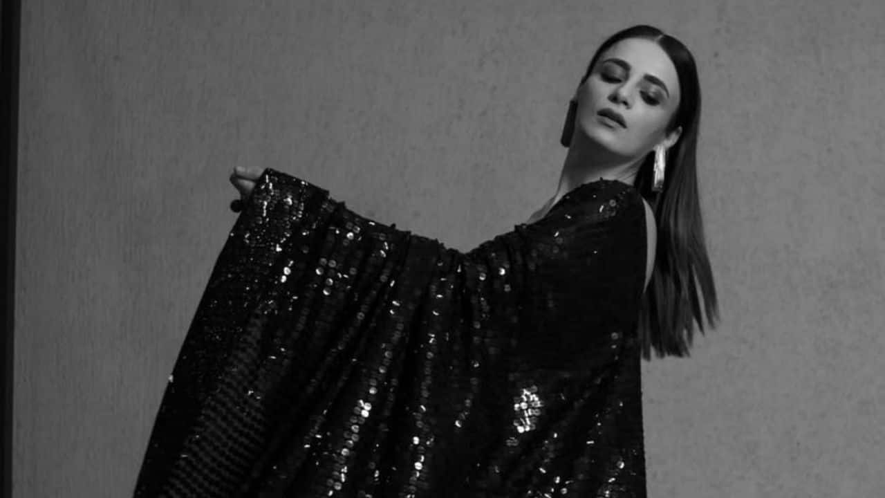 Radhikka Madan Radhikka Madan exuded elegance in a stunning embellished black saree, blending traditional charm with a modern twist by pairing it with a sleek tank blouse. She kept her look polished with sleek, straight hair and elevated her ensemble with delicate tassel earrings and stylish rings.