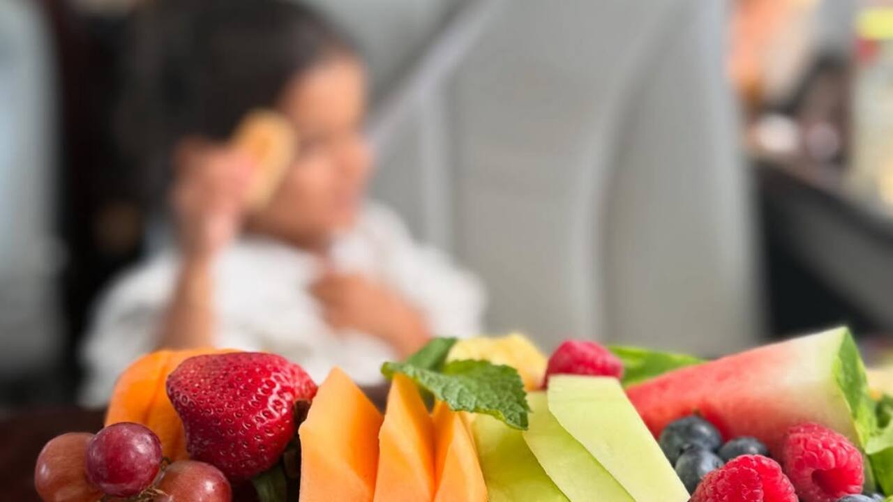 A fresh fruit platter is served while Malti relaxes in the background. Healthy treats for a family day out.