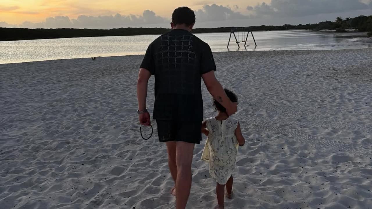 Nick plays with Malti on a lush green lawn. Precious father-daughter time under the open sky.