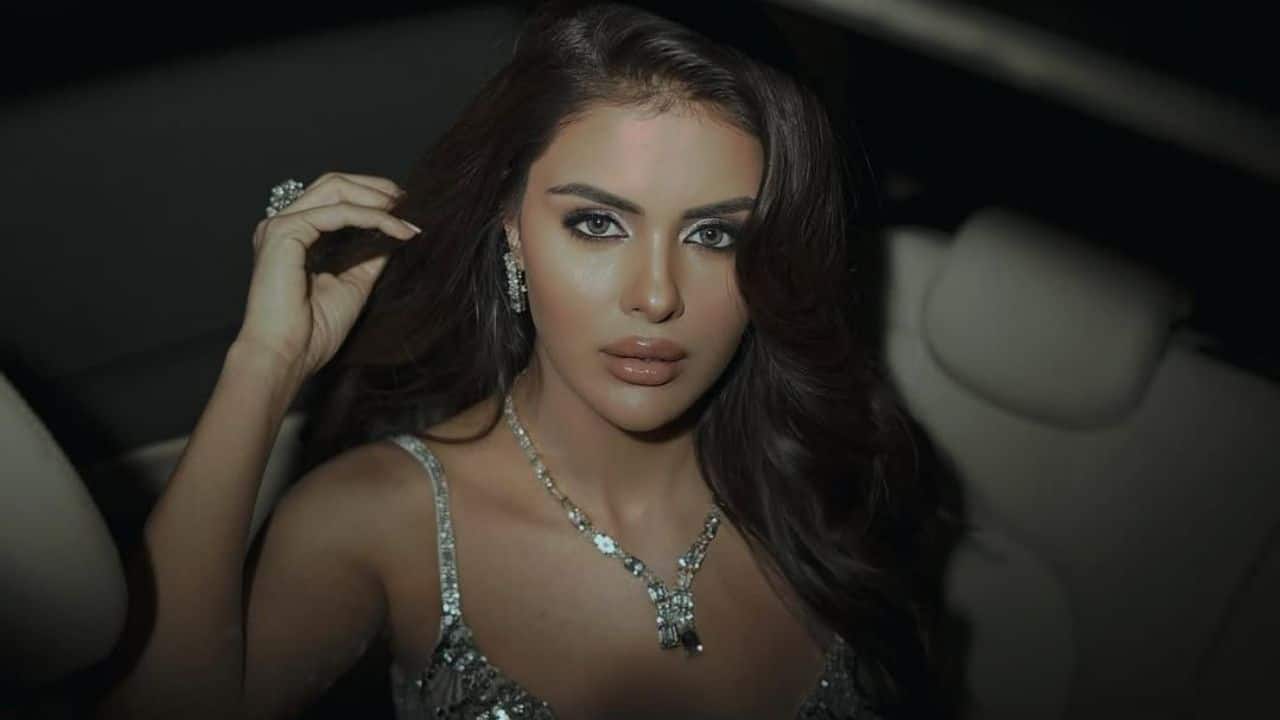 Silver Dress with Bold Makeup &amp; Pendant  The metallic shine of her silver dress is perfectly matched with bold, dramatic makeup and a delicate silver pendant. It’s a look that’s both fierce and feminine.