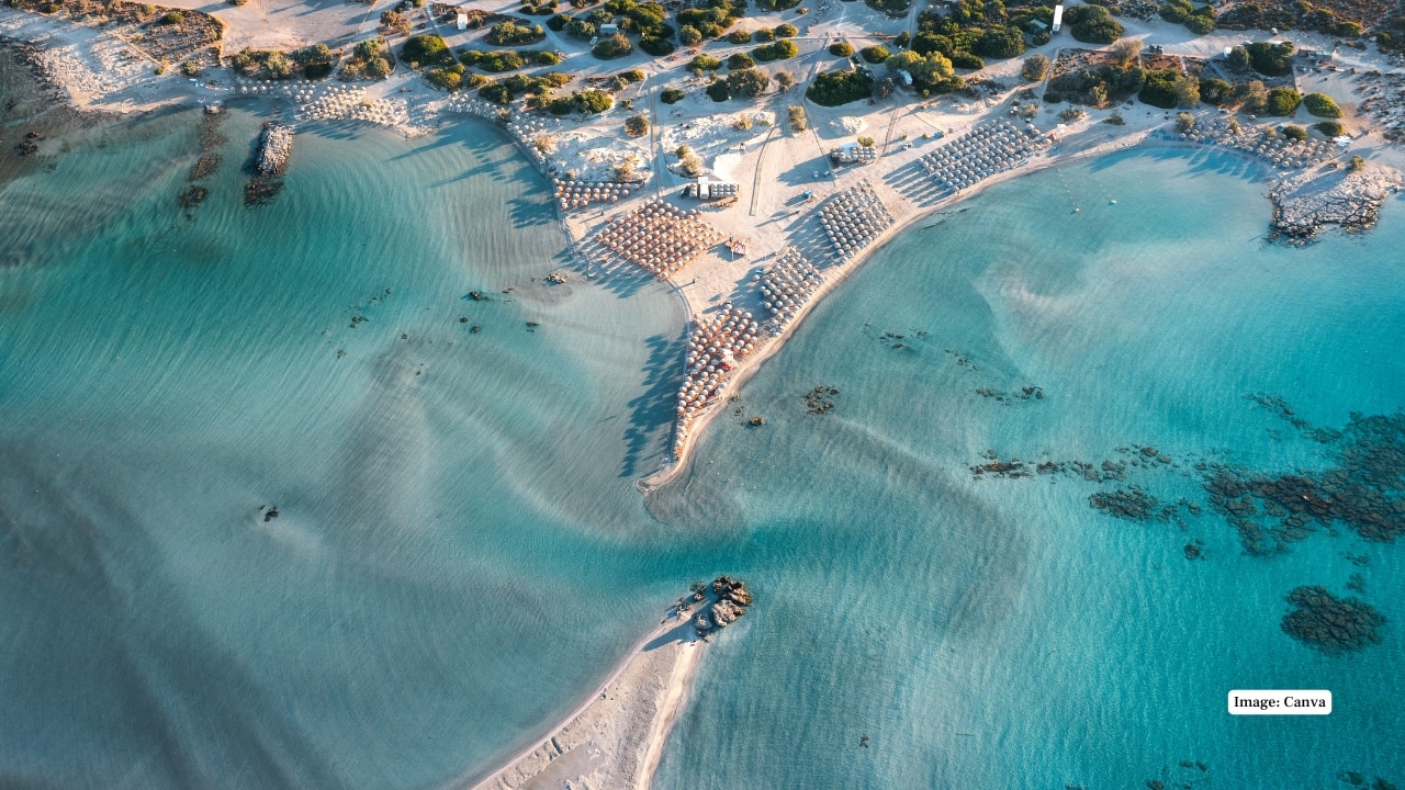 3. Elafonissi Beach, Crete (Greece) A dreamscape of pastel pink sand blending into a blue lagoon. The rosy hue comes from crushed Foraminifera shells, creating a serene and otherworldly shoreline that’s both rare and tranquil. (Image: Canva)