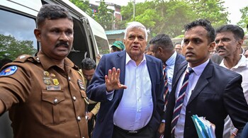 Sri Lanka's former president Ranil Wickremesinghe (C) gestures as he arrives to appear before a court after his arrest in Colombo on August 22, 2025.