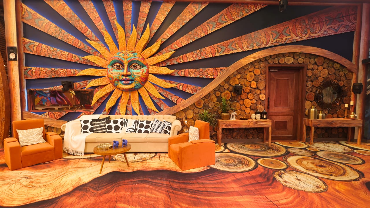 Lounge area This section features an eye-catching lounge that is centred around a huge mural of the sun that depicts a lively human face. A raw, earthy vibe is created by the wood textures that cover the walls and floor. The rustic tables and log-stacked walls finish the wilderness-inspired design, and the seating consists of an orange armchair and a cream sofa, making it perfect for lounging. Lounge area This section features an eye-catching lounge that is centred around a huge mural of the sun that depicts a lively human face. A raw, earthy vibe is created by the wood textures that cover the walls and floor. The rustic tables and log-stacked walls finish the wilderness-inspired design, and the seating consists of an orange armchair and a cream sofa, making it perfect for lounging.