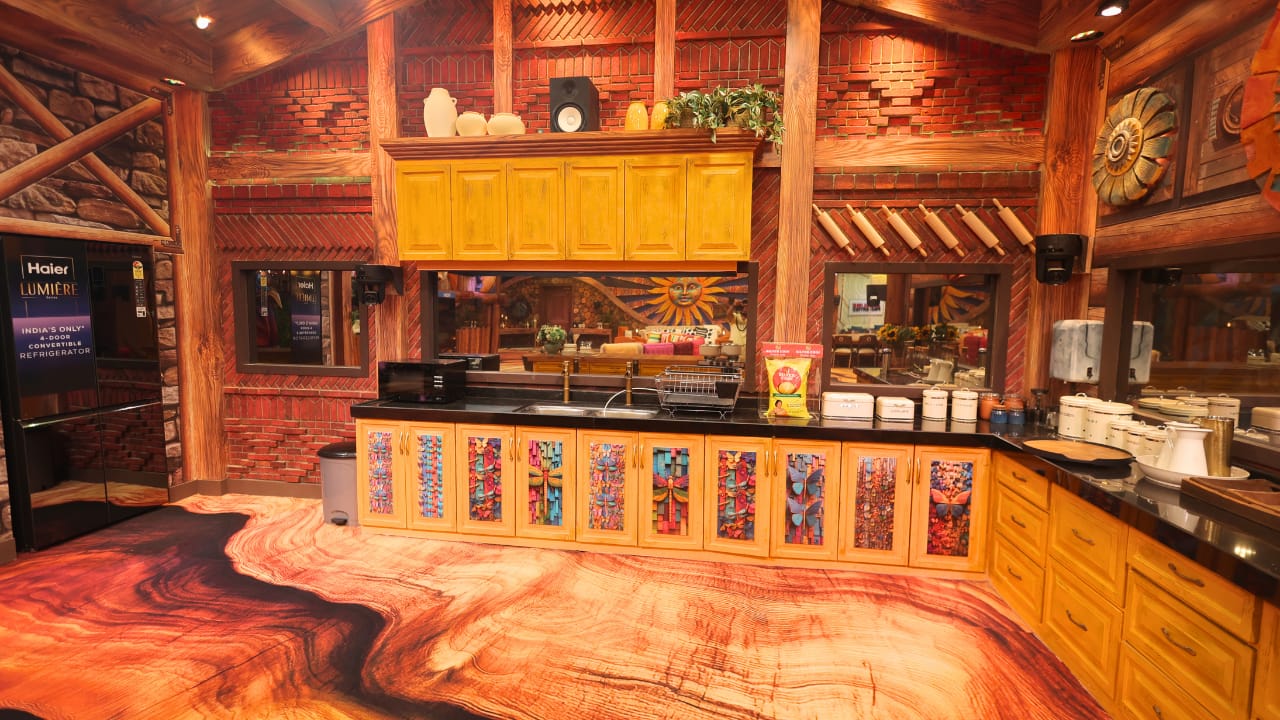 The Kitchen The kitchen will become the real powerhouse. Where the khichdi will be cooked with gossip and decisions. Freely the source of fiery confrontations, the kitchen this year is warm yellows and browns with a wood cabin-like ambience. A bit smaller than in previous seasons, it places contestants in closer quarters. The disagreements over the food, tasks, and cooking will provide the audience with endless drama and entertainment. The Kitchen The kitchen will become the real powerhouse. Where the khichdi will be cooked with gossip and decisions. Freely the source of fiery confrontations, the kitchen this year is warm yellows and browns with a wood cabin-like ambience. A bit smaller than in previous seasons, it places contestants in closer quarters. The disagreements over the food, tasks, and cooking will provide the audience with endless drama and entertainment.