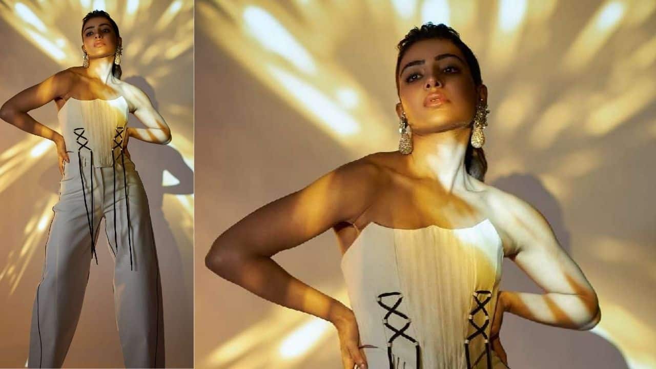 Golden Spotlight Jumpsuit In a chic strapless jumpsuit with black lace-up details, Samantha shines under golden spotlight projections. Paired with statement earrings, the look balances edgy structure with soft femininity, giving her an experimental yet polished appeal.
