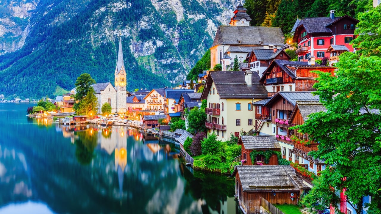 2. Hallstatt, Austria This UNESCO-listed alpine village mirrors fairy-tale perfection—reflections of colorful homes on a placid lake set against soaring peaks. Ancient salt mines and a dramatic skywalk add layers of storybook allure. (Image: Canva)