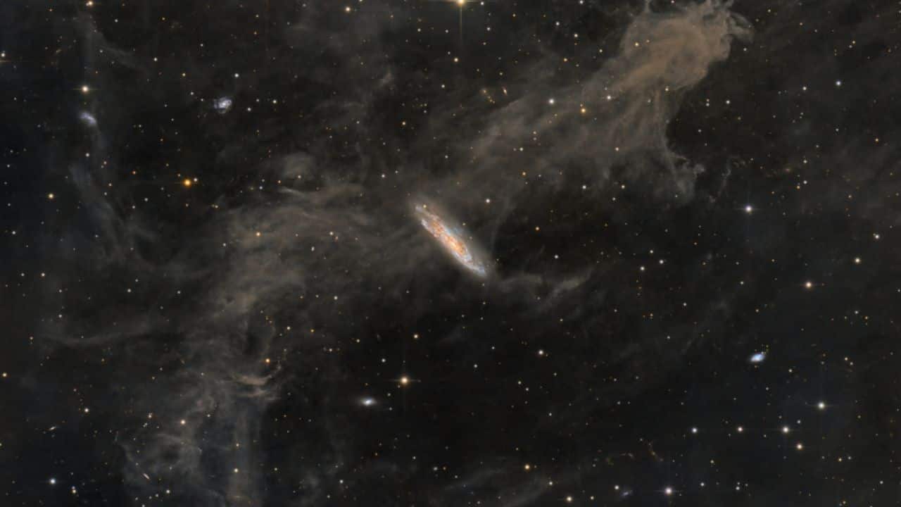 NASA's picture of the day: Stars, dust and galaxies Collide in a striking cosmic scene