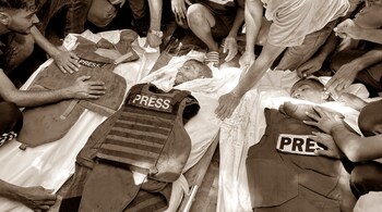 People mourn over the bodies of Palestinian journalists Moaz Abu Taha (L), photojournalist Hussam al-Masri, a Reuters contractor, (C), and Al-Jazeera photojournalist Mohamed Salama, (R), who were killed in an Israeli strike on Nasser hospital in Khan Yunis in the southern Gaza Strip, ahead of their funeral on August 25, 2025.