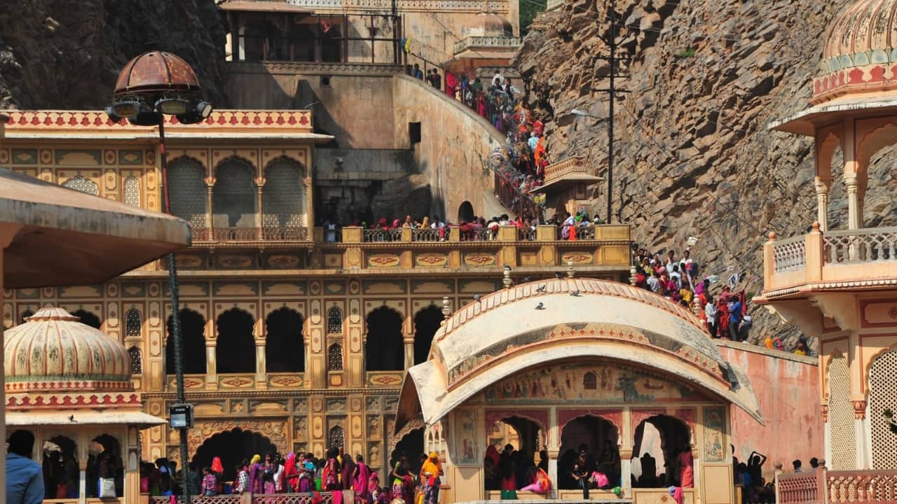 Festivals that Bring Galta Ji Alive Though peaceful for most of the year, the temple comes alive during Makar Sankranti and Kartik Poornima, when thousands of devotees take ritual dips in the kunds. The air fills with chants, hymns, and the rhythmic ringing of bells, creating an atmosphere steeped in devotion. For those lucky enough to witness it, the sight of pilgrims bathing alongside playful monkeys is a uniquely Jaipur experience. (Image: Facebook/ Galta Temple)