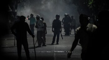 Plainclothes police officers hold sticks as they disperse protesters in front of the Bekasi Metro Police headquarters in Bekasi, West Java on September 1, 2025, amid clashes linked to a wave of protests that have spread across major cities of Indonesia.