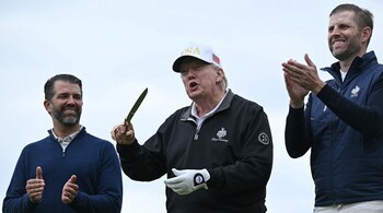 US President Donald Trump (C), flanked by his sons Eric Trump (R) and Donald Trump Jr. (L) reacts after cutting the ribbon on the first tee to officially open the Trump International Golf Links course in Balmedie, Aberdeenshire, north east Scotland on July 29, 2025. (Photo by Brendan SMIALOWSKI / AFP)
