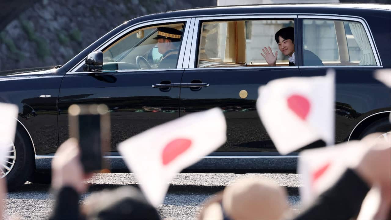 Prince Hisahito waves to people gathered in front of the Imperial Palace for his coming-of-age ceremony, in Tokyo. (Image credit: AFP)