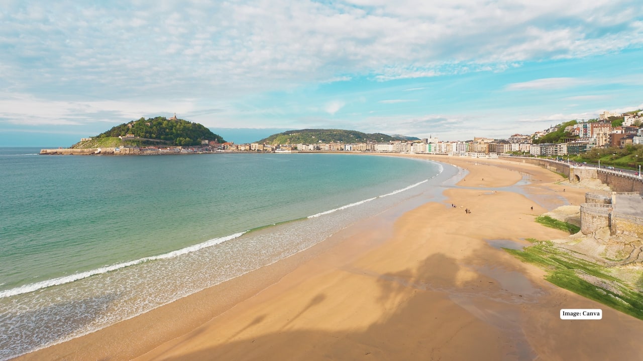 9. Playa La Concha, Spain In San Sebastián, Playa La Concha is where city life meets the sea. This crescent-shaped beach is beloved for swimming, surfing, and evening strolls, framed by elegant promenades and the Basque Country’s renowned cuisine. (Image: canva)
