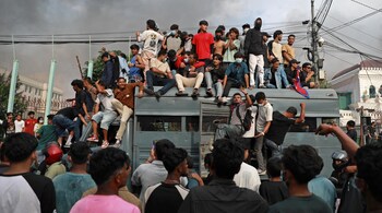Protesters gather on a security vehicle outside the Singha Durbar, the main administrative building of the Nepal government, in Kathmandu on September 9, 2025. (AFP)