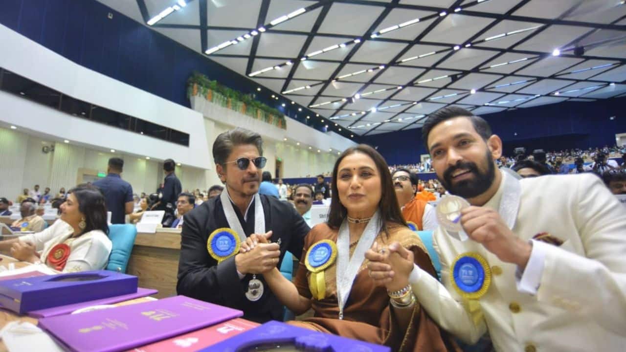 National Award winners pose together Bollywood stars Vikrant Massey, Rani Mukerji, and Shah Rukh Khan were spotted having a heartfelt, joyous moment together at the 71st National Film Awards. Sitting side by side in the front row, all three proudly displayed their medals after receiving recognition for their outstanding performances. The picture, which shows them holding hands with pride and joy, represents both their individual accomplishments and the spirit of Indian cinema as a whole.