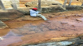 Fatima Li-Hau preparing to sample water from a hot spring at low tide. (Image: Natsumi Noda, ELSI)