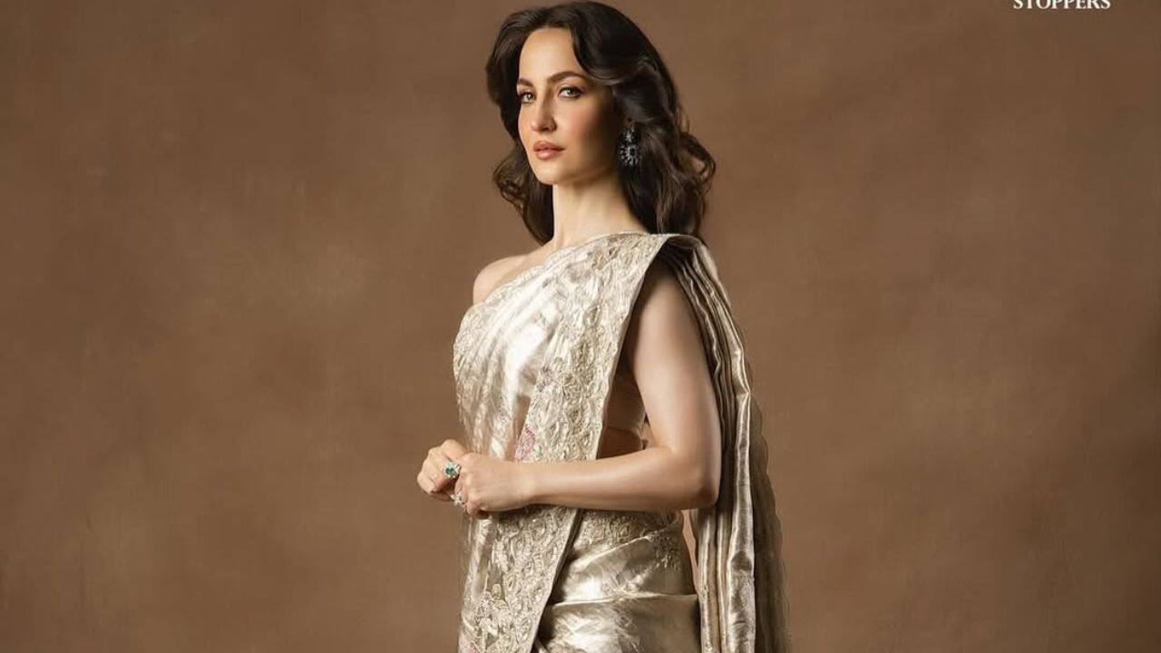 Glistening metallic look Elli AvrRam looks stunning in a incredible metallic saree with beautiful embroidery in shades of gold or silver. A luxurious feel and lavish drape are highlighted by the saree's stylish off-shoulder style. Glistening metallic look Elli AvrRam looks stunning in a incredible metallic saree with beautiful embroidery in shades of gold or silver. A luxurious feel and lavish drape are highlighted by the saree's stylish off-shoulder style.