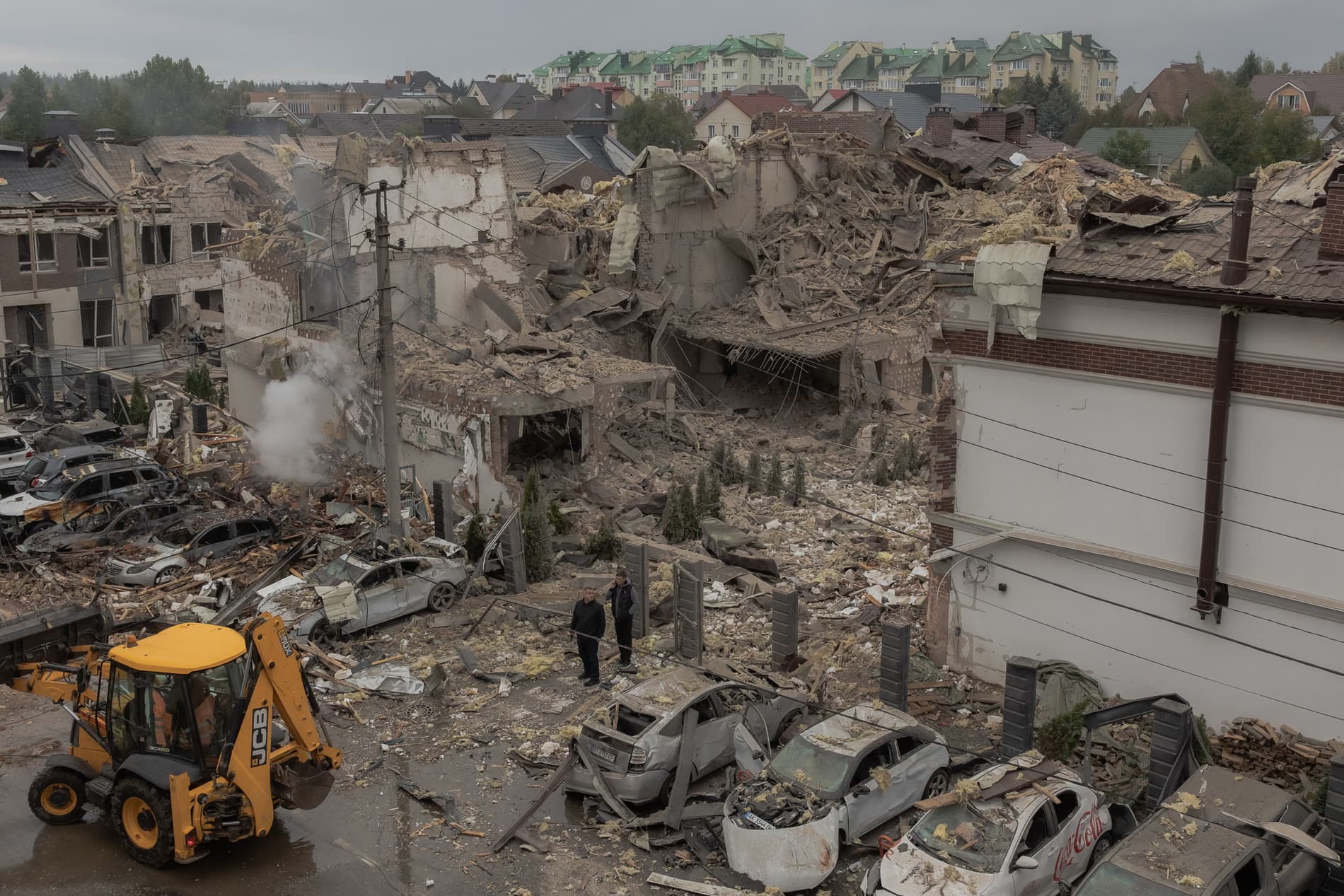 Men stand at the site of heavily damaged residential buildings after a Russian air attack on the outskirts of Kyiv. Photograph: Roman Pilipey/AFP/Getty Images