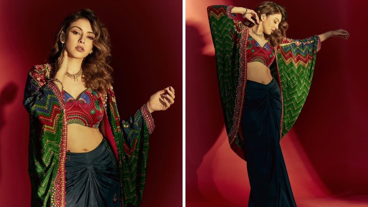 Hansika Motwani Hansika’s fusion fit is a celebration in itself. The green printed jacket with its red accents and freestyle cut pairs well with the cropped red choli and draped skirt. The modern design is comfy yet stylish and glamorous.(Image: Instagram)