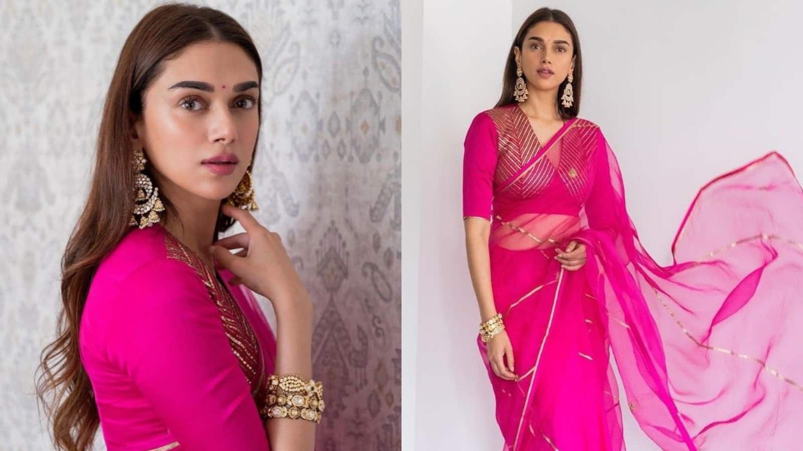 ADITI RAO HYDARI Aditi Rao Hydari is ethereal in a bright magenta sheer organza saree with a gold lace border. She matches it with a half-sleeved V-neck blouse featuring intricate gold thread work, accessorizing with elaborate gold jewelry for a regal, traditional look.