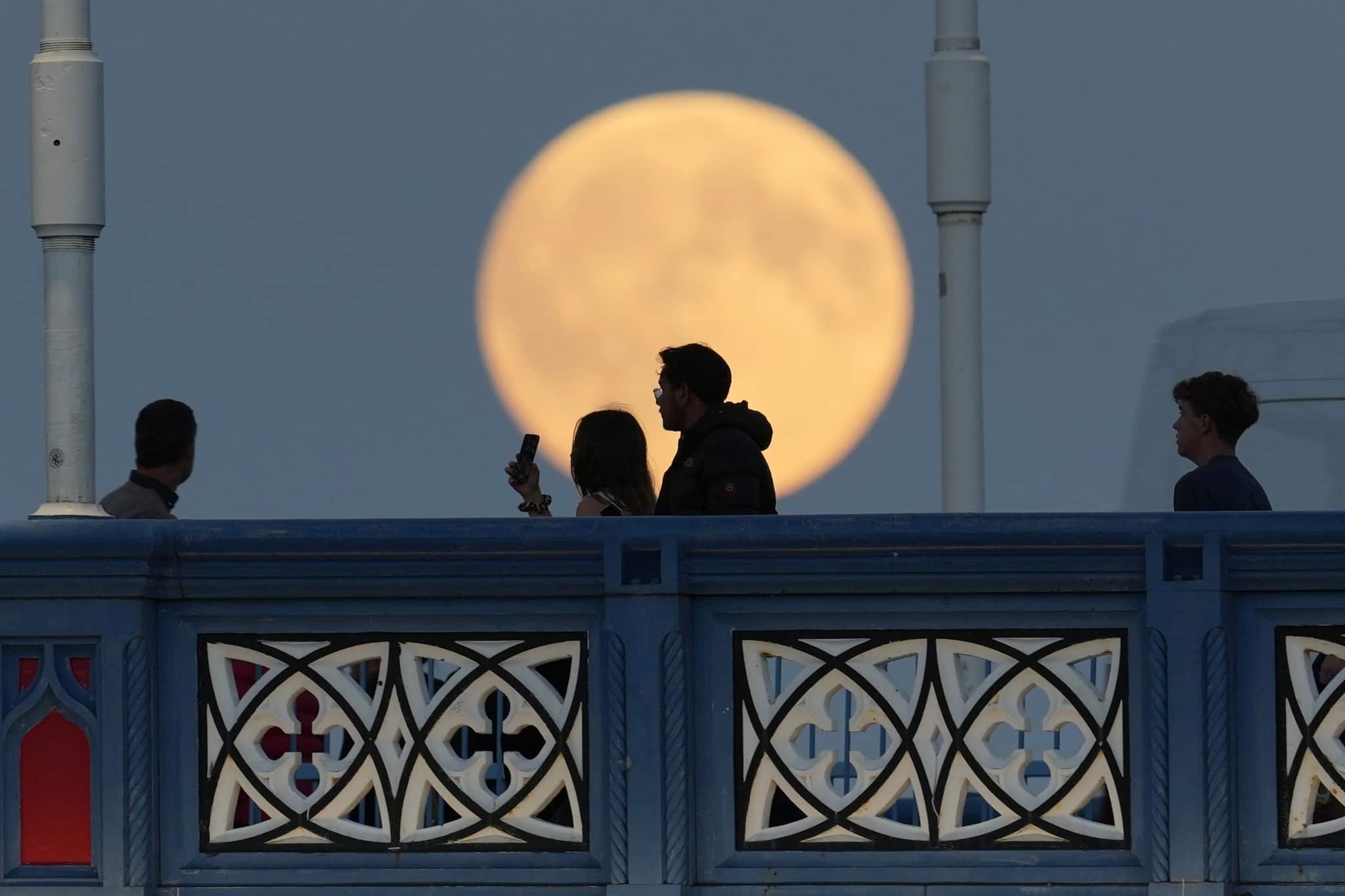 The Harvest Supermoon ascends behind the spires of Milan’s Gothic Duomo on Monday, October 6, 2025. (Image: AP Photo/Luca Bruno)