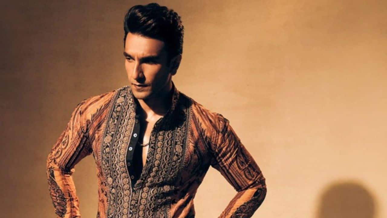 Bold Hues, Timeless Charm Ranveer Singh dressed in a kurta that is skillfully colored, with warm brown and yellow hues and distinctive black patterns and layers. This actor's outfit is simple yet effortlessly charming, perfect for festive celebrations with a touch of class thanks to the front-open chest style, which adds modern appeal.