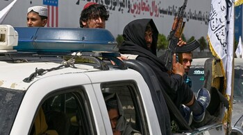 Taliban fighters ride on a police pickup truck during celebrations marking the fourth anniversary of the U.S. withdrawal and the start of Taliban rule in Kabul, Afghanistan, Friday, Aug. 15, 2025. (AP Photo/Nava Jamshidi)
