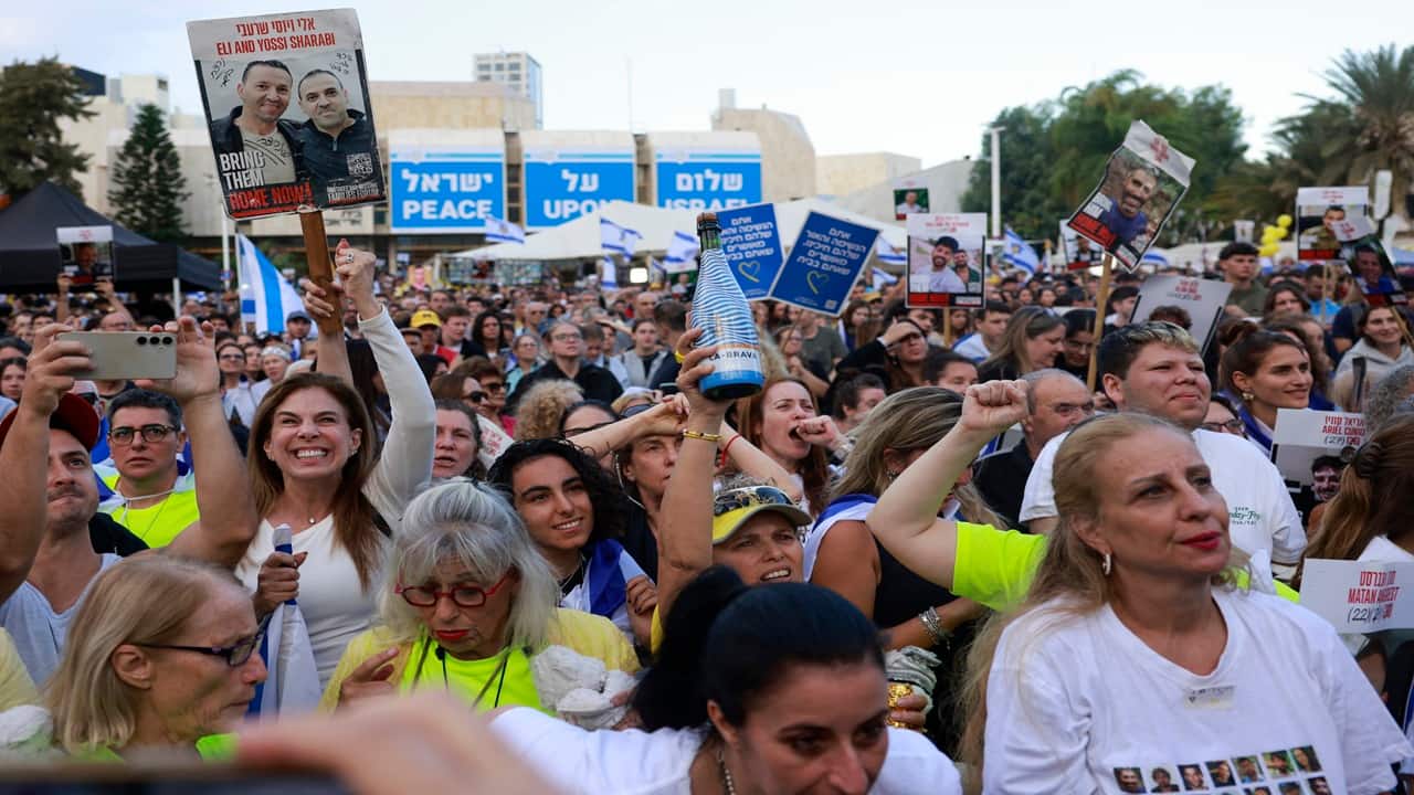                                                                                                                                                                                                                                                                People gather at Hostage Square in Tel Aviv as they wait for the release of Israelis still held in Gaza. Families, friends, and supporters waved Israeli flags, wore yellow ribbons, held photos of captives, and prepared personal tributes such as T-shirts printed with hostages’ images, reflecting the mix of relief, anticipation, and emotional tension surrounding the homecoming.