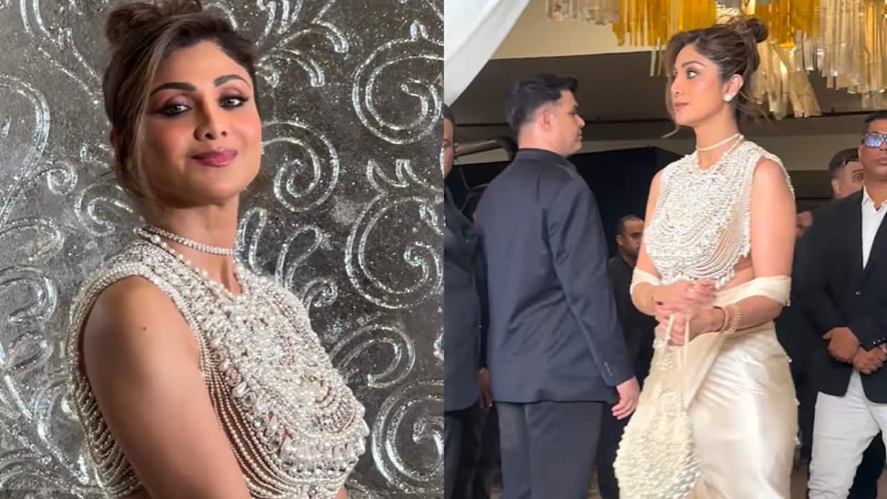 Shilpa Shetty Shilpa Shetty sported a glamorous off-white saree draped in a modern style. Her sleeveless blouse is the highlight, heavily embellished with cascading pearls and beads. She completed her look with a diamond choker necklace.