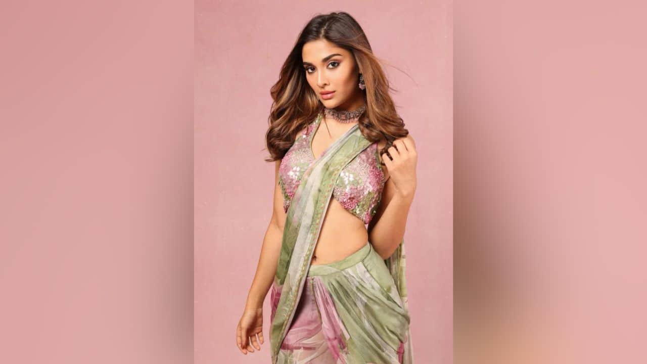 Saiee Manjrekar Wearing a light green floral saree with pink accessories, Saiee Manjrekar offers a stunning Diwali look. The deep V-neck blouse with heavy pattern work, likely in a contrasting color like pink, looks stunning on the actress with the saree, having Silver Silk Line Georgette with digital print and silk lines. This gives the traditional outfit a glamorous and modern edge that is ideal for festive gatherings.