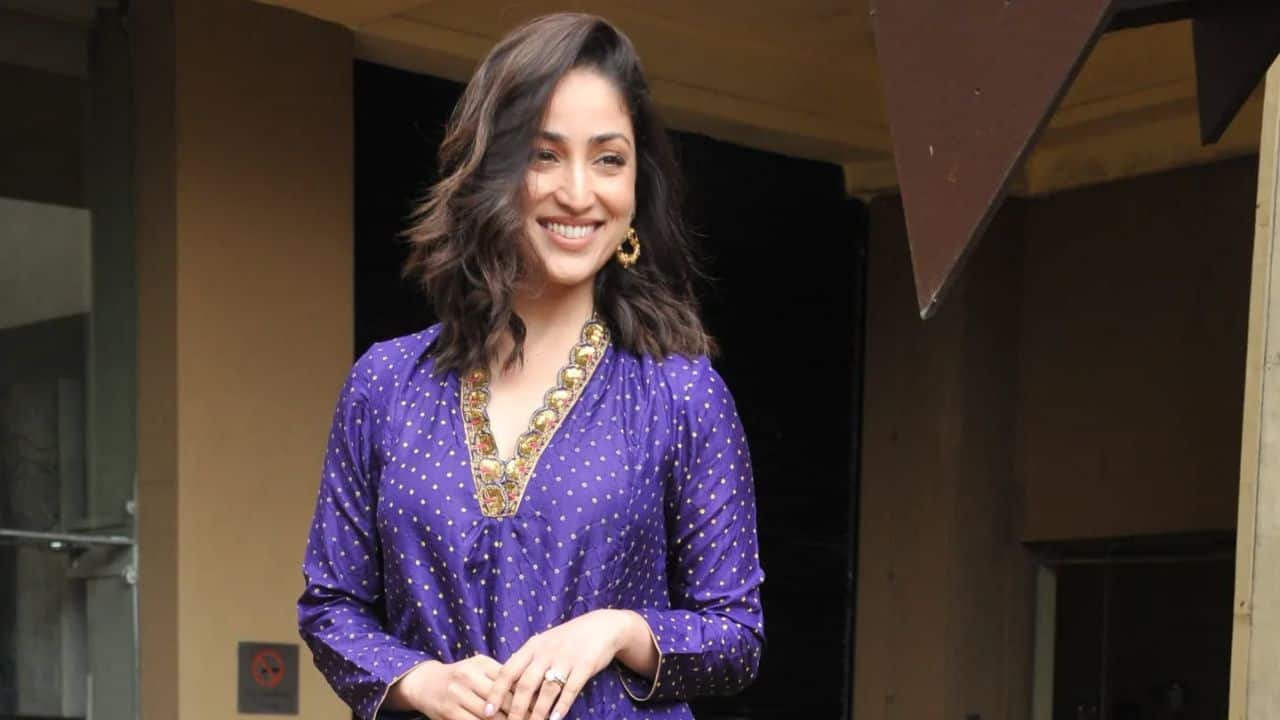 Yami Gautam Yami radiates regal elegance while wearing a rich purple kurta set with golden polka dots. Festive charm is reflected by the subtle shimmer of the fabric and the fine embroidery on the neckline. This look is an overview in subtle glamour, perfect for individuals who value traditional ethnic style with a contemporary twist. The actress's soft curls and minimal jewelry let the entire look take the spotlight.
