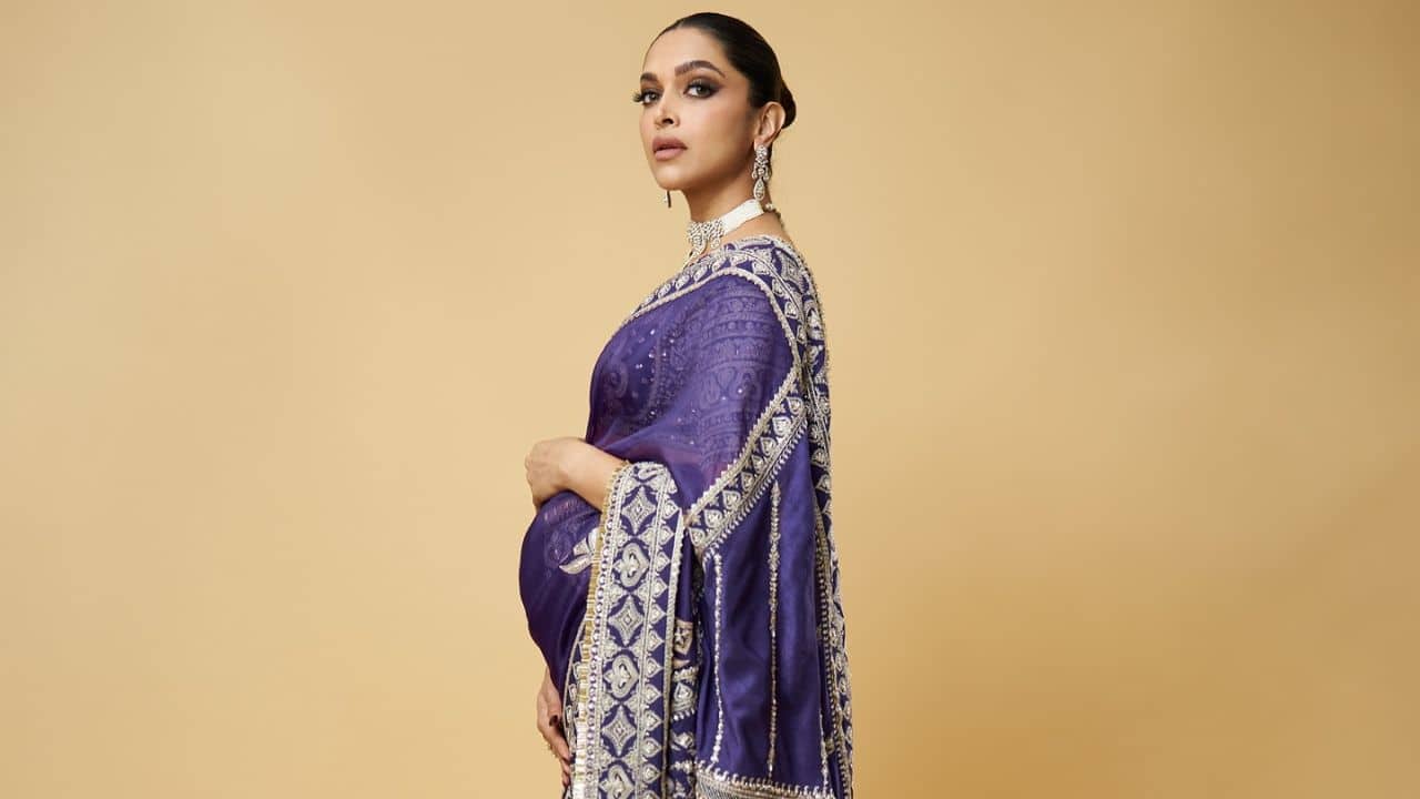 A royal look in ethnic wear In her purple Torani saree with hand embroidery and jewel tones, Deepika Padukone possesses regal elegance. For a gorgeous, traditional look, the intricate embroidery and dori work are beautifully paired with a statement pearl necklace and matching earrings.