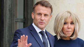 French President Emmanuel Macron (L) waves next to French President's wife Brigitte Macron as they pose before a meeting with Jordan's Crown Prince at the Elysee Palace in Paris on October 8, 2025. (Photo by Ludovic MARIN / AFP)