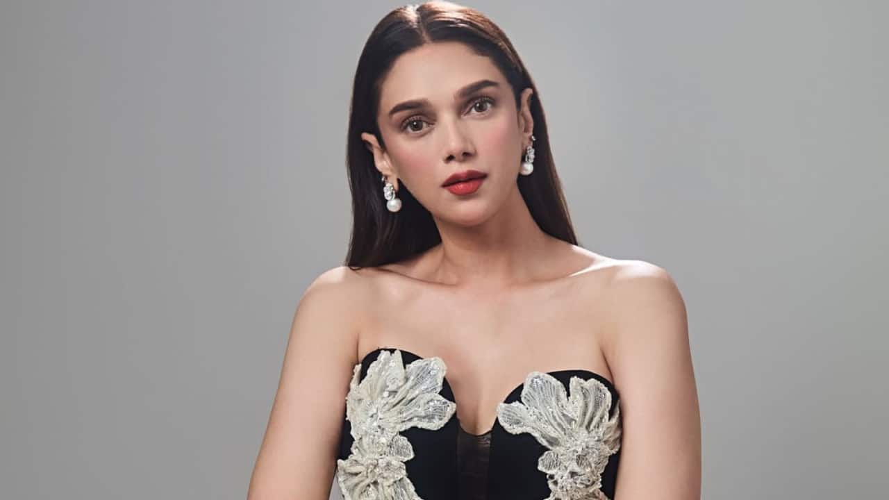 Black Midi Dress In a black midi dress with white floral embroidery around the bust, Aditi exuded sophistication. Her curves were accentuated by the form-fitting design, and the drama was heightened by the modest thigh slit. She accessorised her look with pearl jewellery and wore her hair straight.