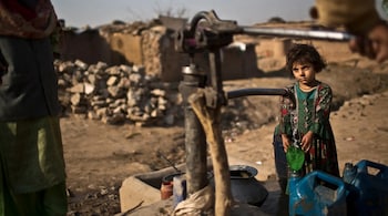 File image of Afghan refugees pumping water by hand in a slum of Islamabad, Pakistan. (AP Photo)