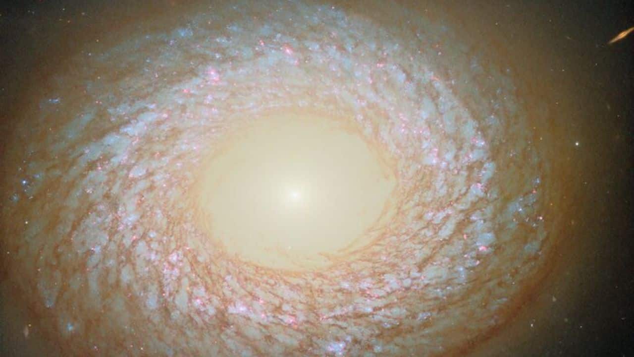 Hubble’s image of NGC 2775 shows a mysterious galaxy blending spiral and elliptical traits, lying 67 million light-years away in Cancer, possibly shaped by past galactic mergers. (Image: ESA)
