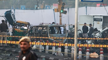 A policeman stands guard as investigators examine the site of Monday's car explosion near the historic Red Fort, in New Delhi