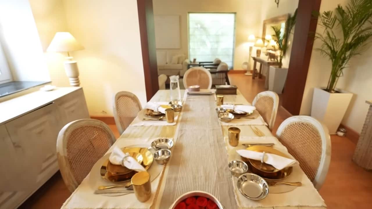 <strong>Dining area:</strong> One of the most popular spots of the house, the dining area looked breathtaking with its muted interiors, the unique dining table, and the consoles. It also featured table lamps that added the right lighting. It’s the antique touch that makes the whole setting come alive. (YouTube/@curlytalesdigital)