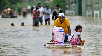 A man pushes a makeshift raft along a flooded street after heavy rainfall in Ambatale on the outskirts of Colombo on November 29, 2025. (Photo by Ishara S. KODIKARA / AFP)