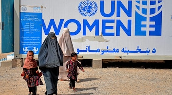Afghan burqa-clad women and their children, walk at a refugee registration centre after their arrival from Pakistan, in Takhta Pul district in Kandahar province on June 24, 2025. (Photo by Sanaullah SEIAM / AFP)