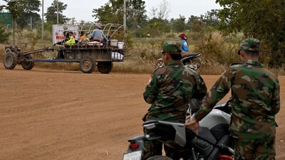 Soldiers stand guard as displaced residents evacuate with their belongings in their vehicle during clashes along the Cambodia-Thailand border in Cambodia's Siem Reap province on December 10, 2025. (AFP)