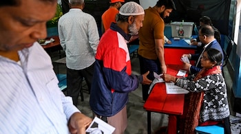 (FILES) People check their names in the electoral rolls to cast their votes at a polling station during Bangladesh's general elections in Dhaka on January 7, 2024. (Photo by Munir UZ ZAMAN / AFP)