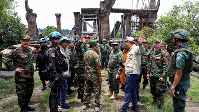 This pool photo taken and released on August 20, 2025 by Agence Kampuchea Presse (AKP) shows Cambodian and foreign military personnel speaking during a visit organized by Cambodia's Ministry of Defence following the CambodiaThailand border conflict at the Preah Vihear temple in Preah Vihear province. (Photo by POOL / AFP)